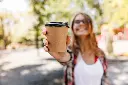 blur-portrait-adorable-woman-holding-cup-coffee-carefree-stylish-girl-enjoying-summer-day.webp